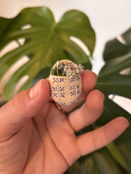 Tiny tiled wall planter held between two fingers